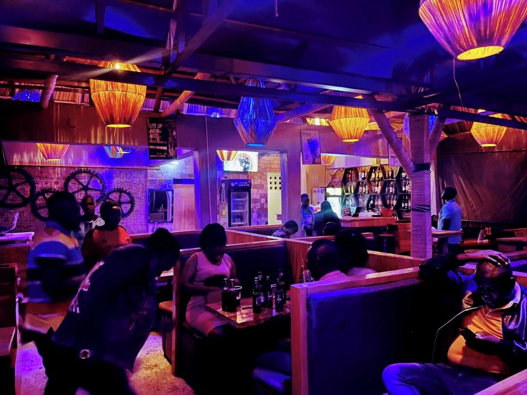 Una zona de bar con asientos, una barra y un letrero que dice 'LIFE UP HERE'.