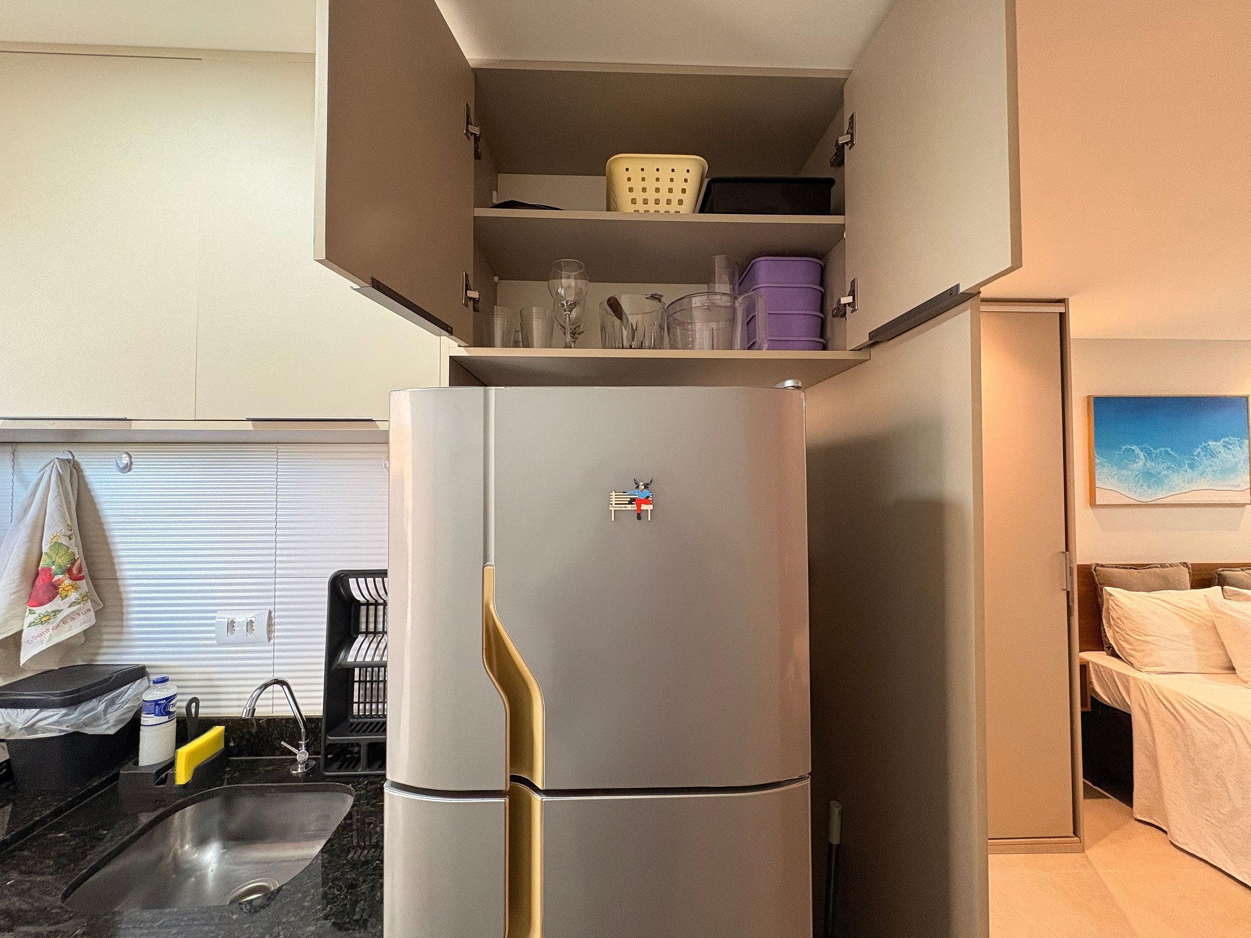A compact kitchen with a built-in refrigerator, a sink, and a small countertop.