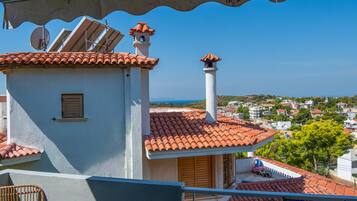 A residential building with a red-tiled roof, a chimney, and a satellite dish.