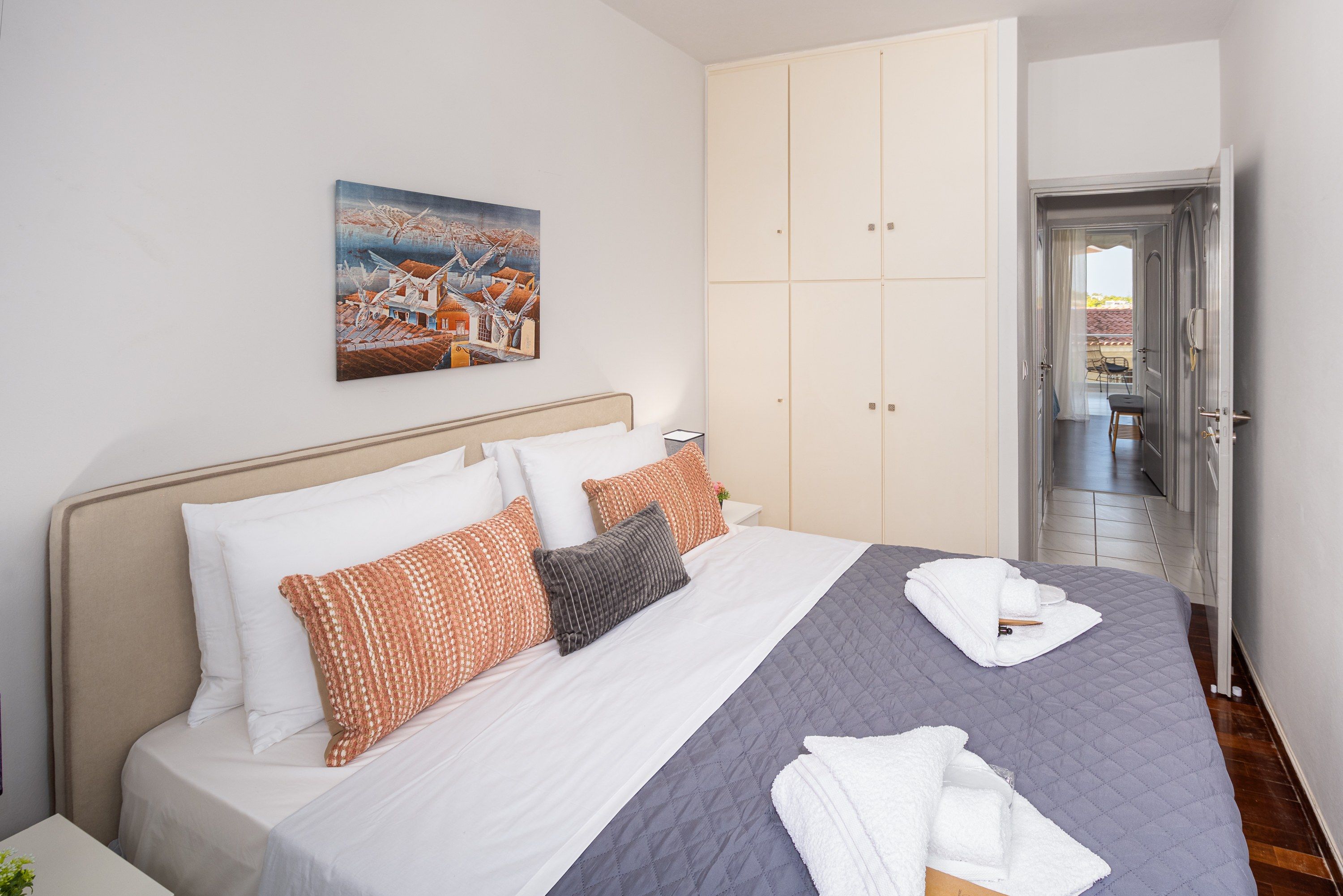 Una habitación de hotel con una cama, un cuadro y vistas al exterior.