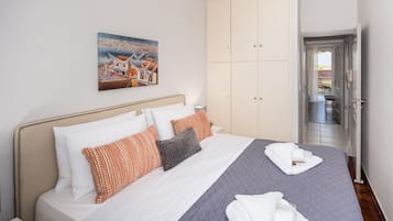 Una habitación de hotel con una cama, un cuadro y vistas al exterior.