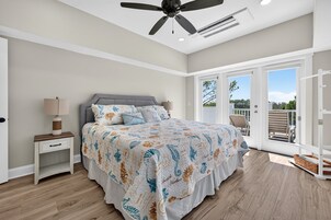 Un dormitorio con cama, mesita de noche y ventilador de techo.