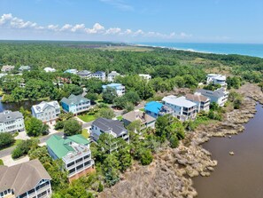 A coastal residential area with houses adjacent to a body of water, surrounded by dense greenery. - Eagles Nest 6 Bedroom Home (Georgetown)