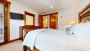 A bedroom with a large bed, a wooden dresser, a television, and a mirror. - Snowcreek Vi The Lodges #1153 2 Bedroom Condo (Mammoth Lakes)