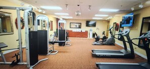 Ein Fitnessstudio mit Laufbändern, Crosstrainern und Gewichten.