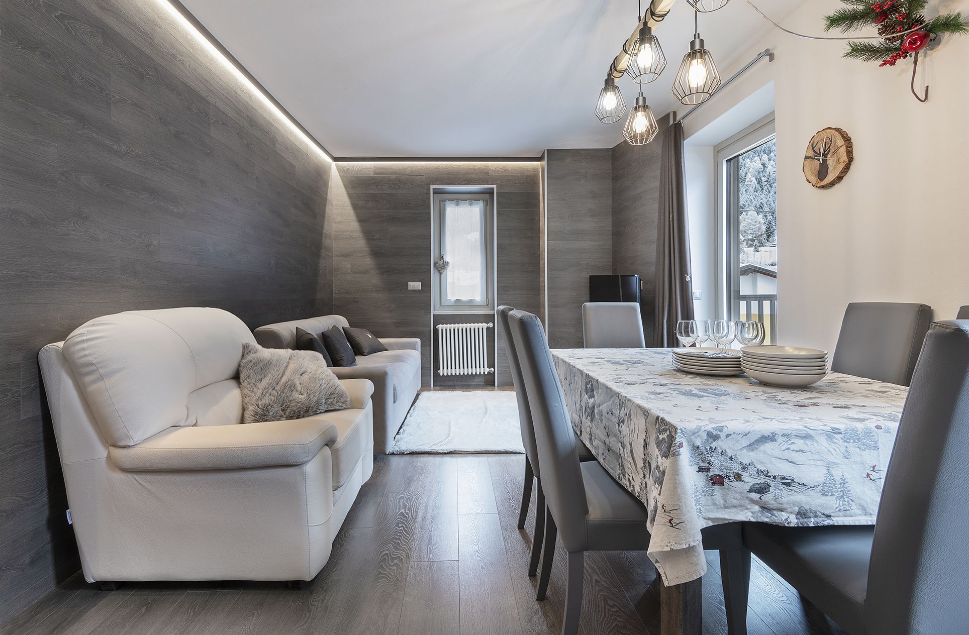 A modern dining area with a marble table, leather chairs, and a cozy seating arrangement.