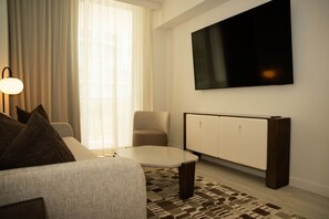 Een moderne woonkamer met een bank, een salontafel, een televisie en een radiator.