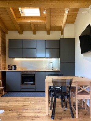 Una cocina moderna con armarios empotrados, una mesa de madera y sillas.
