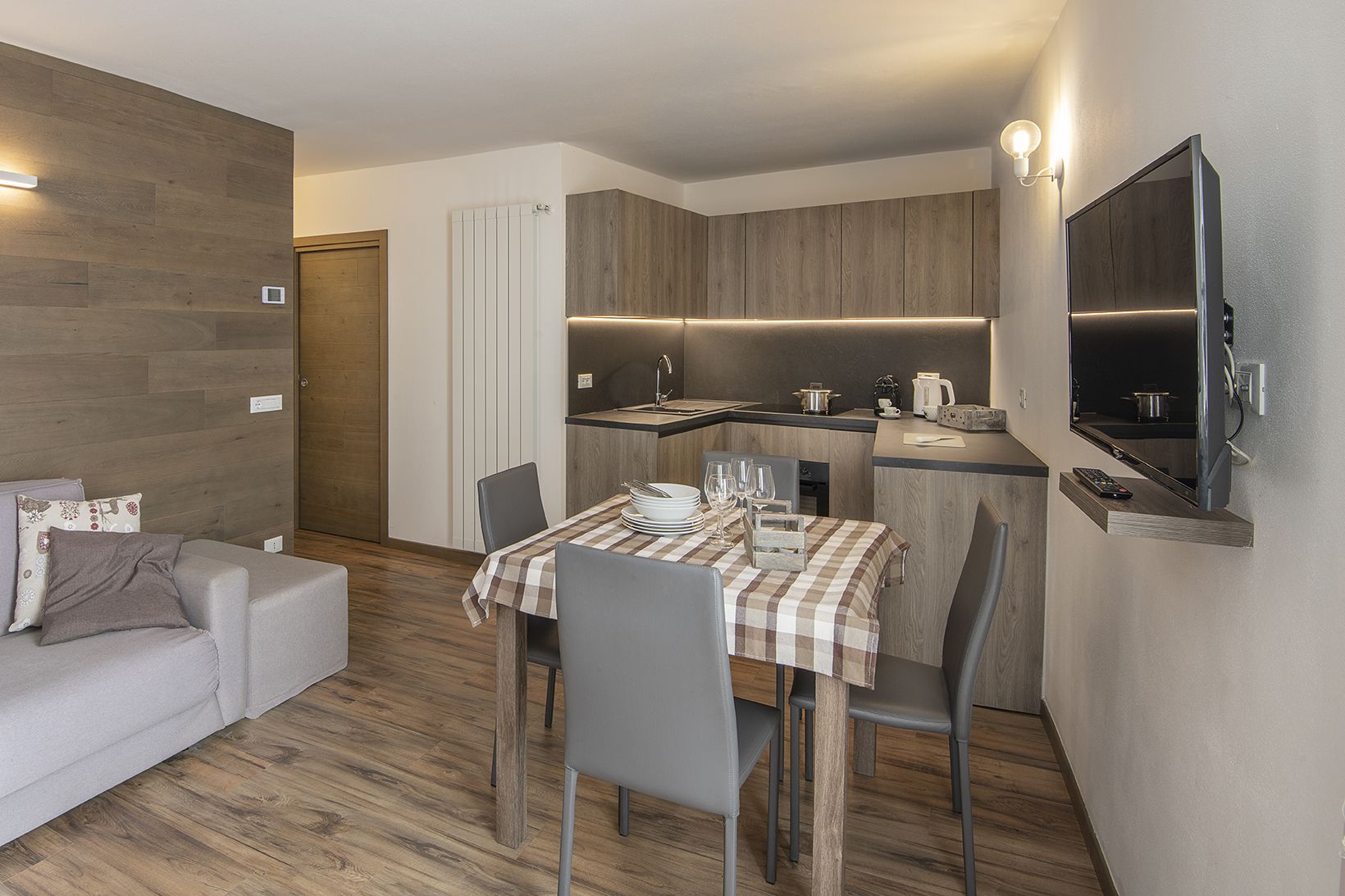 A compact living space with a kitchenette, dining area, and a seating area with a sofa.