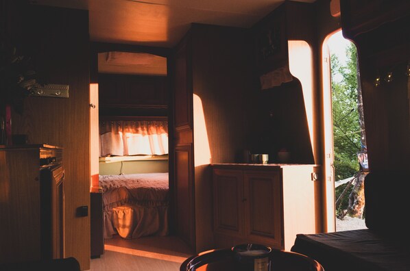 Un interior acogedor con una cama, una mesita y un armario.