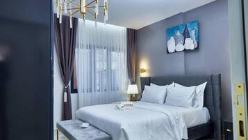 Een moderne hotelkamer met een groot bed, een nachtkastje, een lamp en een schilderij aan de muur.