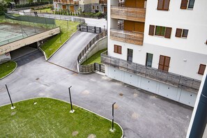 A multi-level residential building with balconies, a gated driveway, and a small parking area. - AffittiPontediLegno-Sofia&Ferdy Alpine LuxuryView (Ponte di legno)