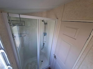 A glass-enclosed shower with a showerhead and a handheld shower attachment. - Golden Sands Haven, Sunflower Haven (Mablethorpe)