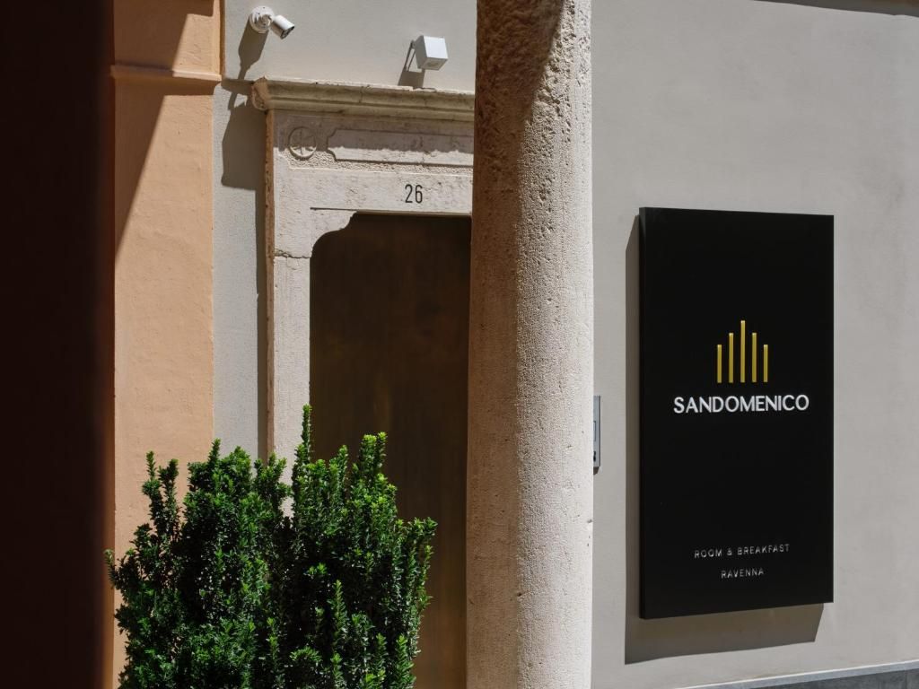 Fachada de edificio con columna, puerta con el número '26' y cartel que indica 'SANDOMENICO ROOM & BREAKFAST RAVENNA'.