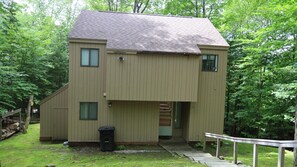 A two-story building with a sloped roof, a front porch, and a small attached structure. - Private home in Waterville Estates! (Thornton)