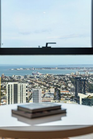 Vista desde una ventana con vista a un paisaje urbano que incluye edificios, una masa de agua y un barco.