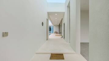 A modern interior with a straight hallway leading to a dining area.