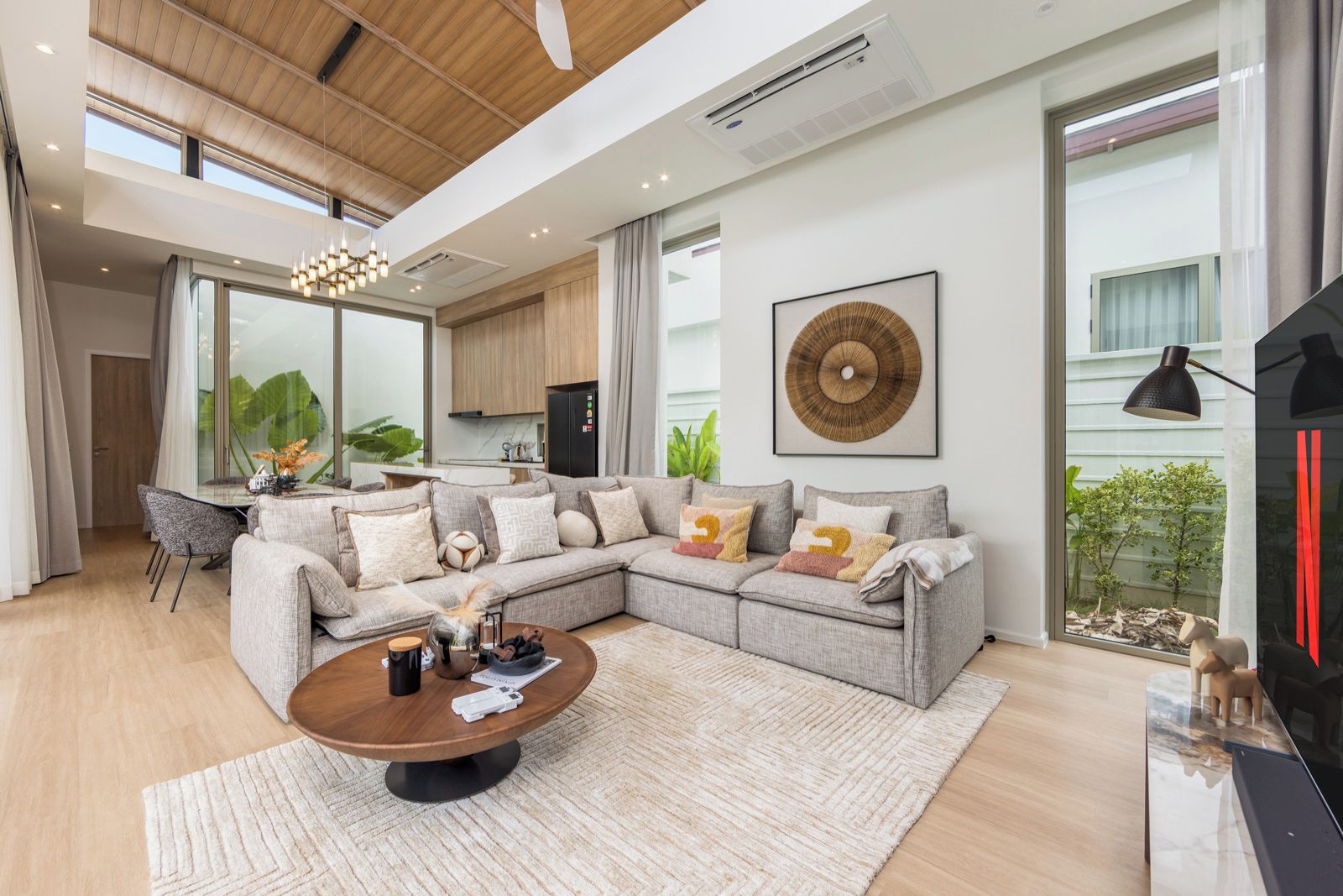 Una sala moderna con un sofá modular, una mesa de centro y un ventanal grande.