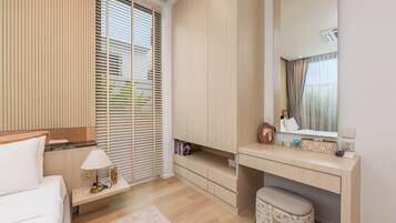 A modern bedroom with a bed, bedside table, lamp, and a desk with a mirror.