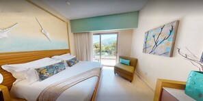 A hotel room with a bed, a sofa, a painting, and a view of the outdoors.