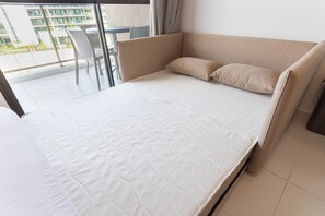 Habitación de hotel moderna con cama, una silla y vistas al exterior.