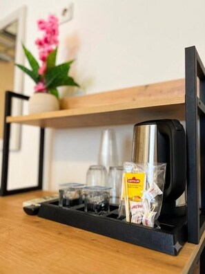 Una cafetera y cristalería sobre una encimera de madera.