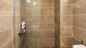 Un baño moderno con ducha de vidrio, inodoro y lavamanos.