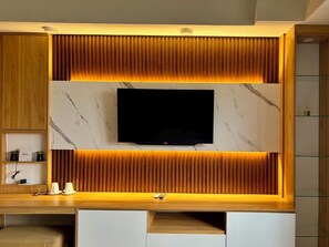 Ein modernes Unterhaltungselement mit einem Flachbildfernseher, Holzvertäfelung und Marmorelementen.
