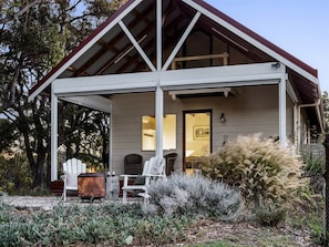 A covered porch with a wooden structure, outdoor seating, and a view of the interior. - Cottage at Dunmore Homestead | Peaceful Retreat (Scott River East)