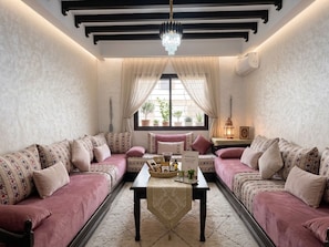 Ein gemütliches Zimmer mit zwei Sofas, einem Tisch mit Tablett und einer Kandelaber.