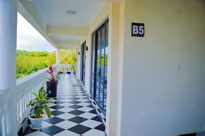 A corridor with a checkered floor, potted plants, and a sign indicating room number B5. - The Coastal Nest Diani Beach (Diani Beach)