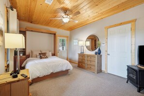 A bedroom with a bed, dresser, mirror, lamp, and a ceiling fan. - Deer Mountain Retreat: Mountain Views: Hot Tub (Ellijay)