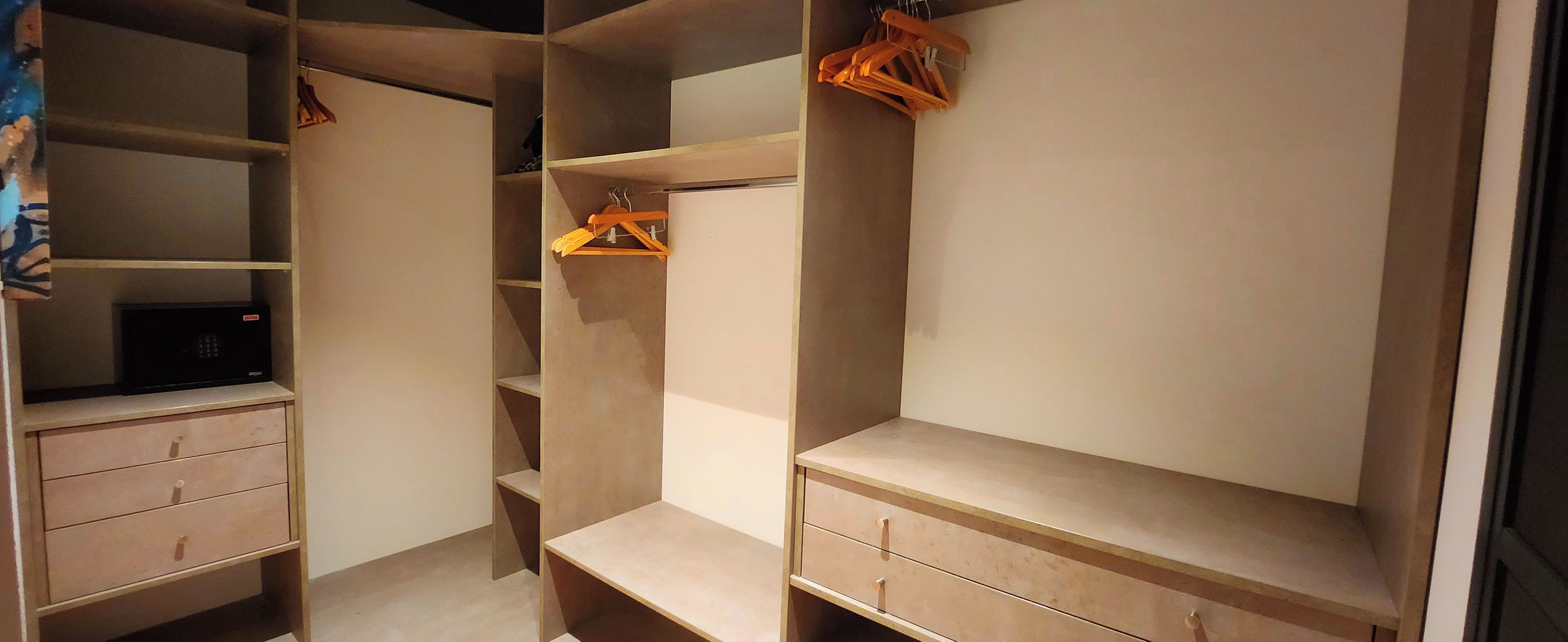A walk-in closet with multiple shelves and drawers, some with hangers.