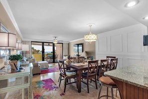 A dining area with a table, chairs, and a view of the outdoors. - Edgewater Beach Condo 202 (Destin)