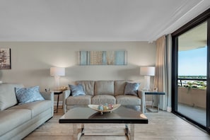 Ein modernes Wohnzimmer mit einer Couch, zwei Beistelltischen und einem Couchtisch.