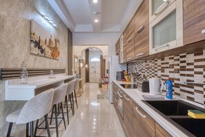 Una cocina moderna con barra, armarios de madera y salpicadero de azulejos.