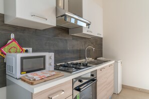 Eine moderne Küche mit Mikrowelle, Herd, Backofen und integrierter Dunstabzugshaube.