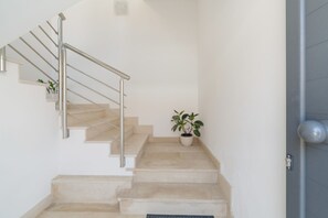 A staircase with a metal handrail, beige steps, and a potted plant on the landing. - Apartment 'Lungomare Avola  with Sea' with Balcony, Wi-Fi and Air Conditioning (Avola)