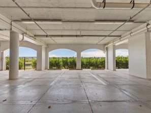 An empty parking garage with concrete floors and white pillars. - Waterfront Condo In Placida (PLACIDA)
