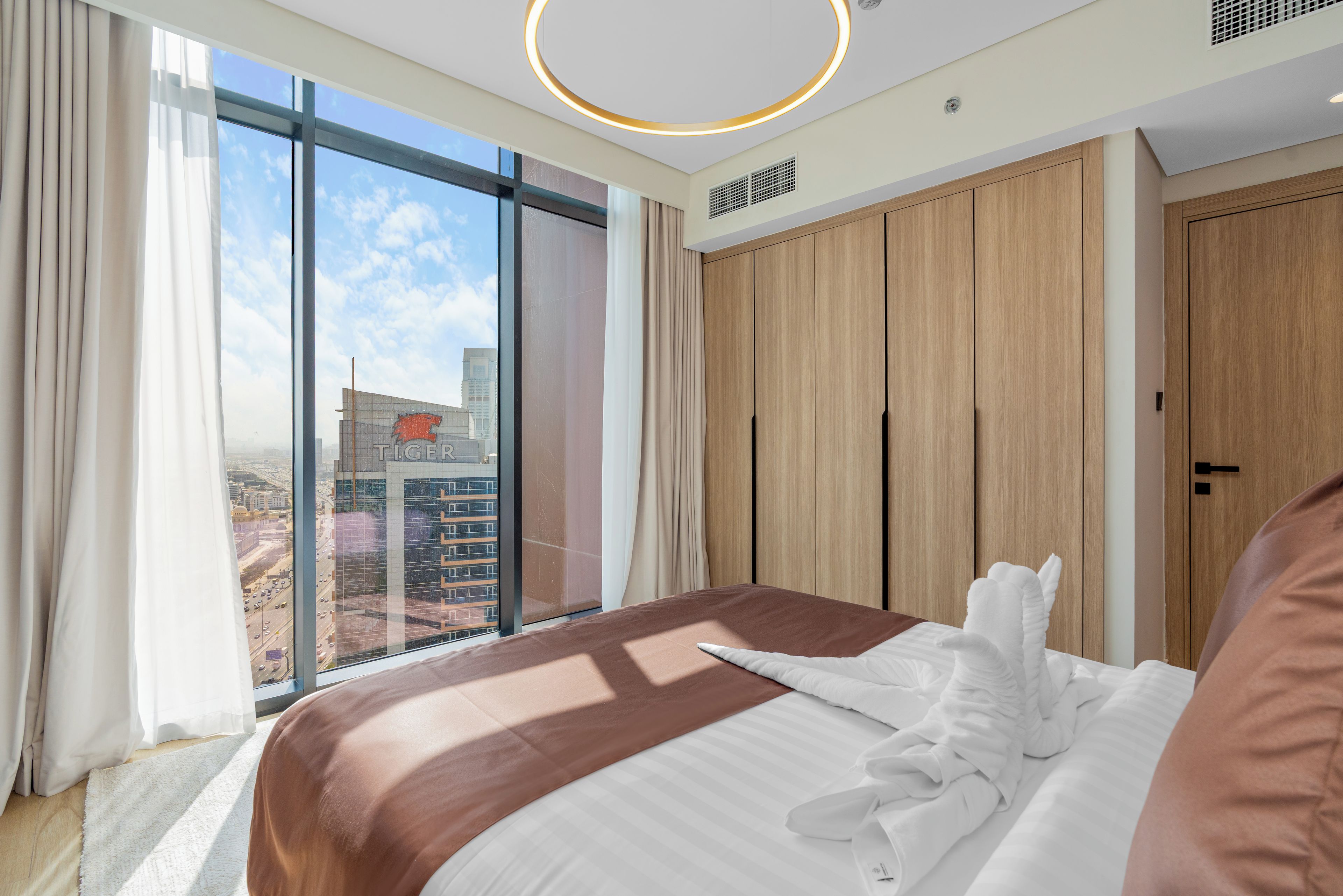 A hotel room with a large bed, a view of the city, and a modern design.