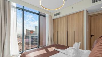 A hotel room with a large bed, a view of the city, and a modern design.
