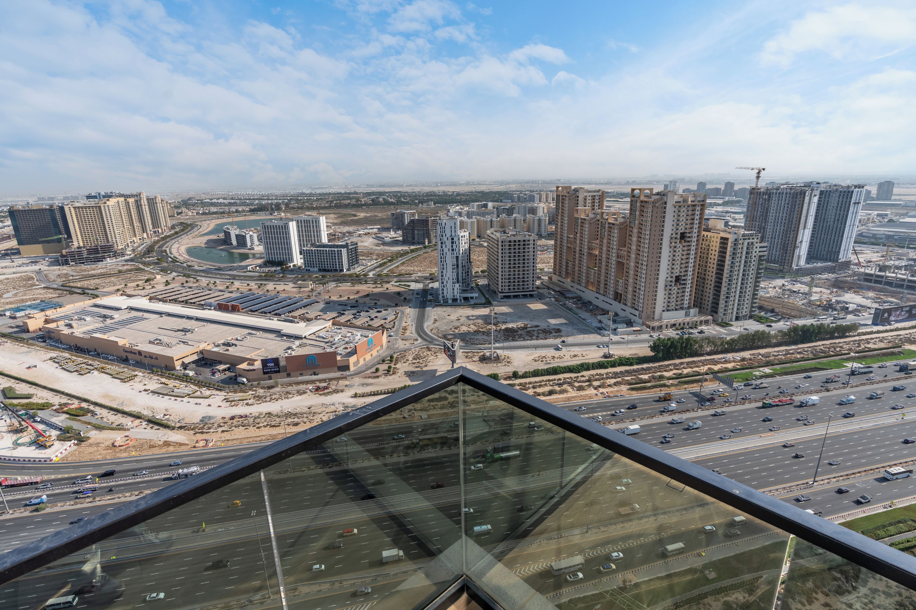 A high-rise building with a view of a cityscape, including roads and other buildings.