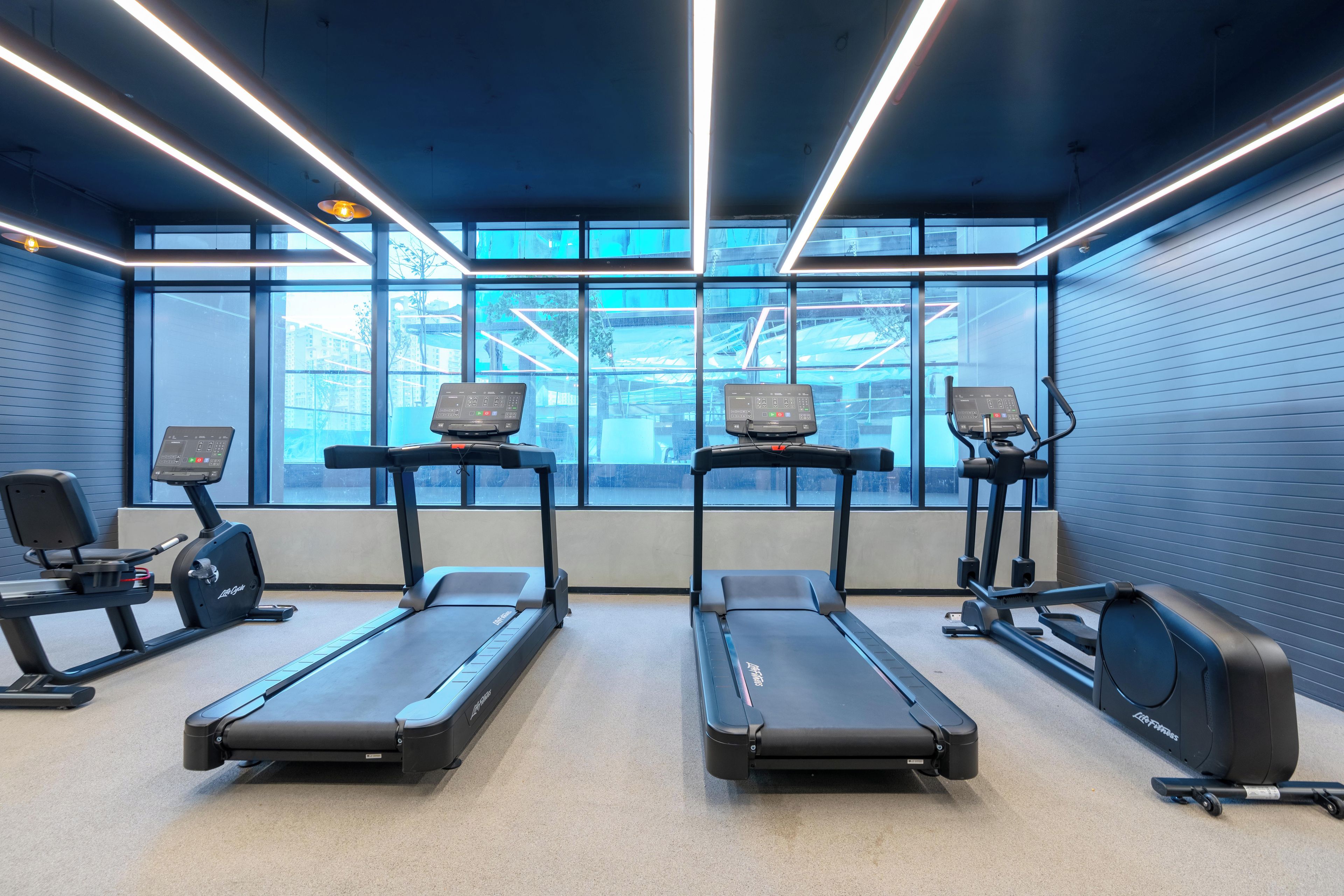 Et fitnesscenter med løbebånd, spinningcykler og træningsudstyr.