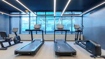 Et fitnesscenter med løbebånd, spinningcykler og træningsudstyr.