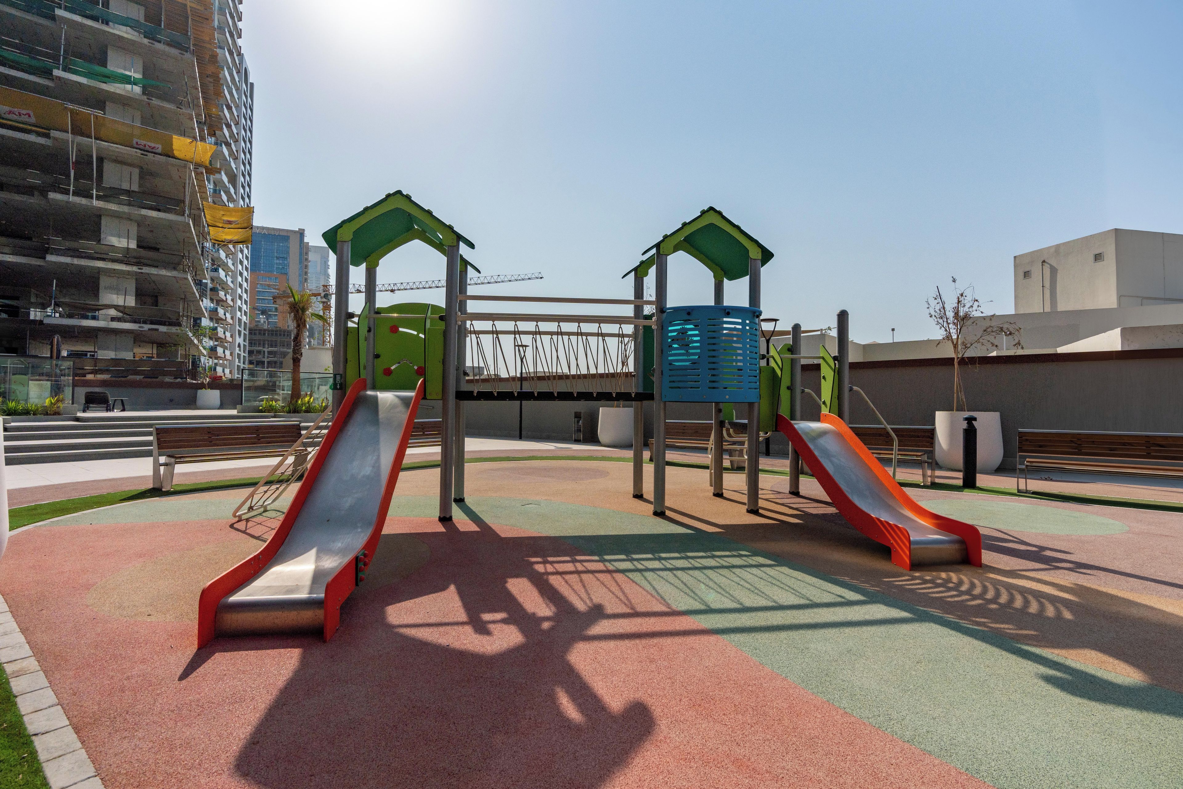 A playground with two slides and a climbing structure.