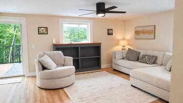 A living room with a sofa, armchair, and a bookshelf.