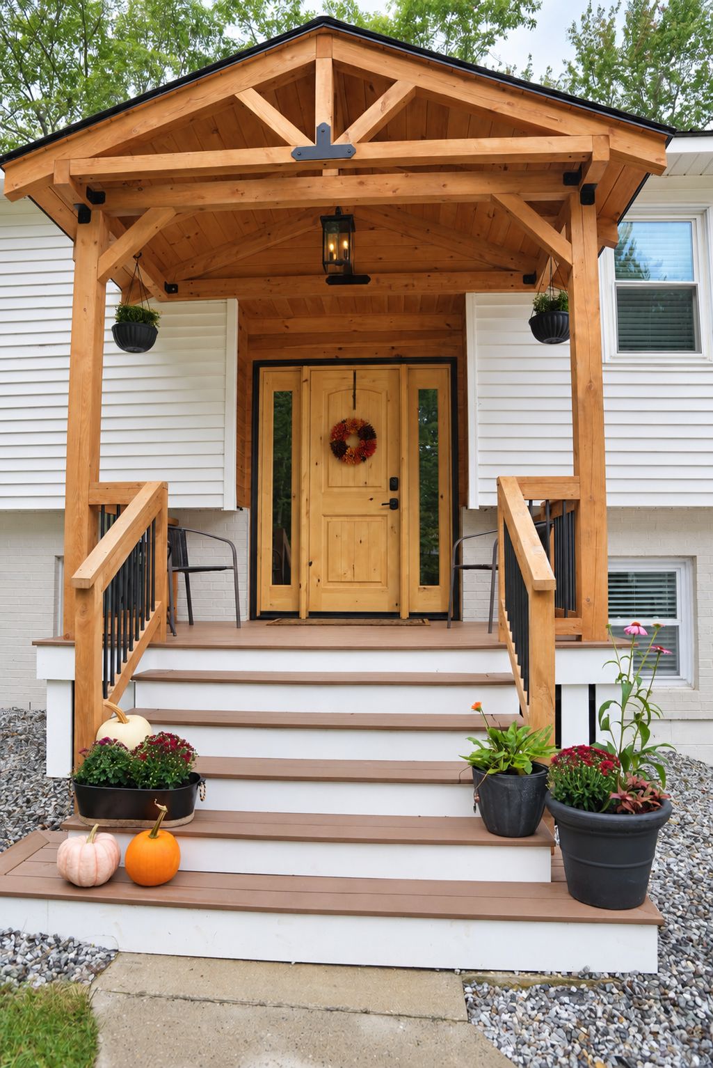 A wooden porch with a door, steps, and potted plants.