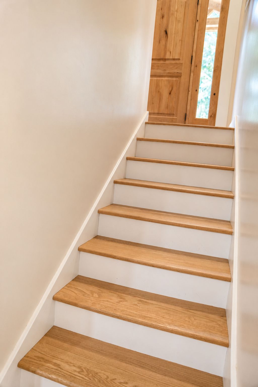 A staircase with wooden steps and white walls.