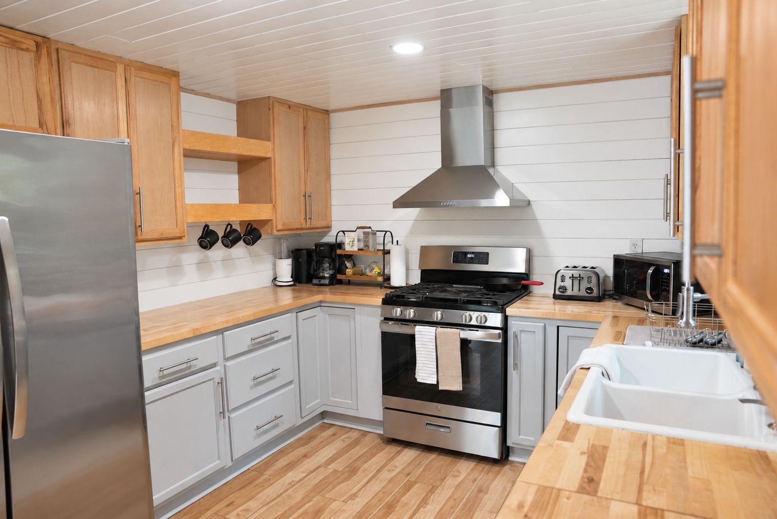 Eine moderne Küche mit Edelstahlgeräten, Holzschränken und einem eingebauten Backofen.