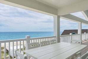 A covered outdoor seating area with a view of the ocean. - Oceanfront | 10 Bedrooms | Game Room | Pool | Theater (Emerald Isle)